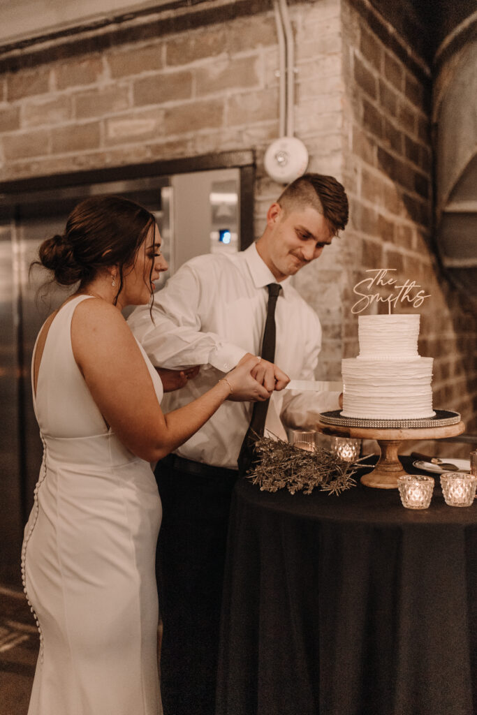 cutting the cake in industrial iowa wedding venue