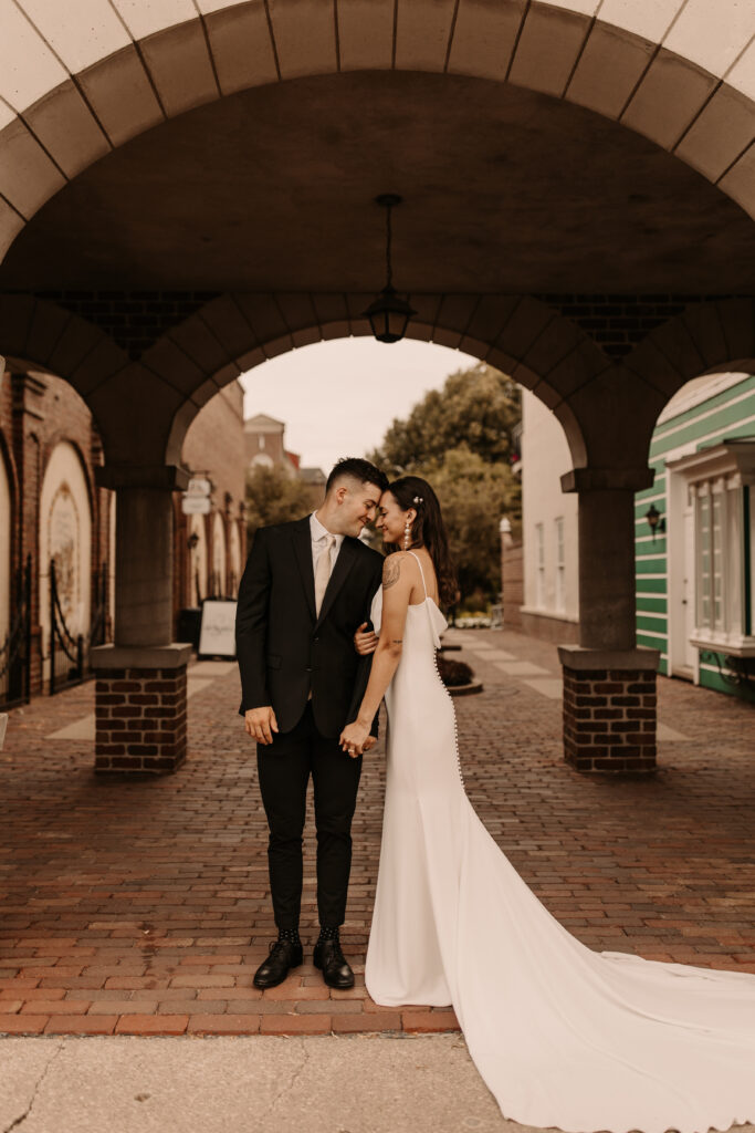outdoor bride and groom portraits under arched architecture 