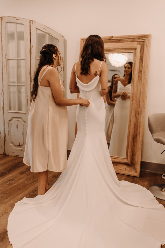 bride getting into sleek and elegant wedding gown